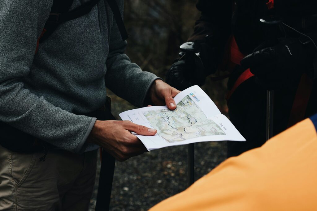 Group of hikers planning their route with a map during an outdoor adventure.